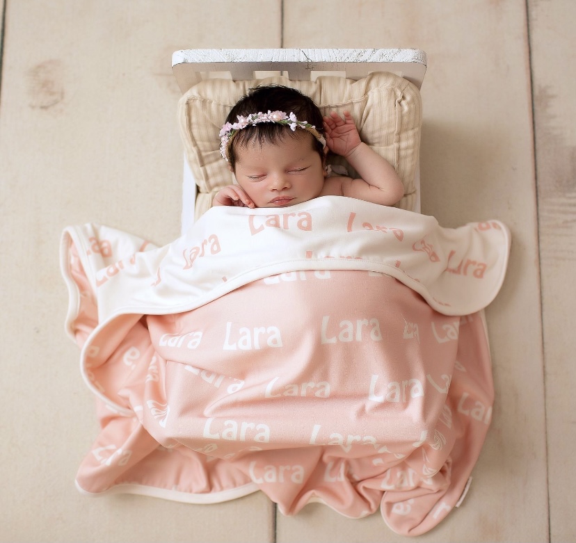 imagem de bebê reborn coberto por uma manta personalizad