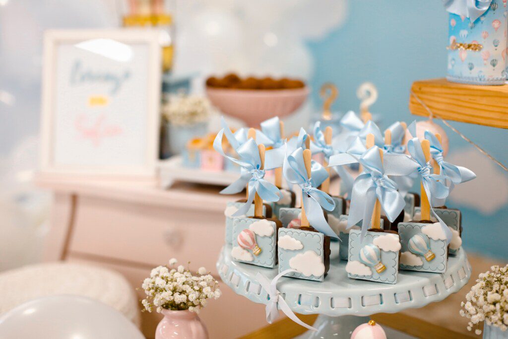 mesa decorativa com  lembranças de chá de bebê na cor azul 