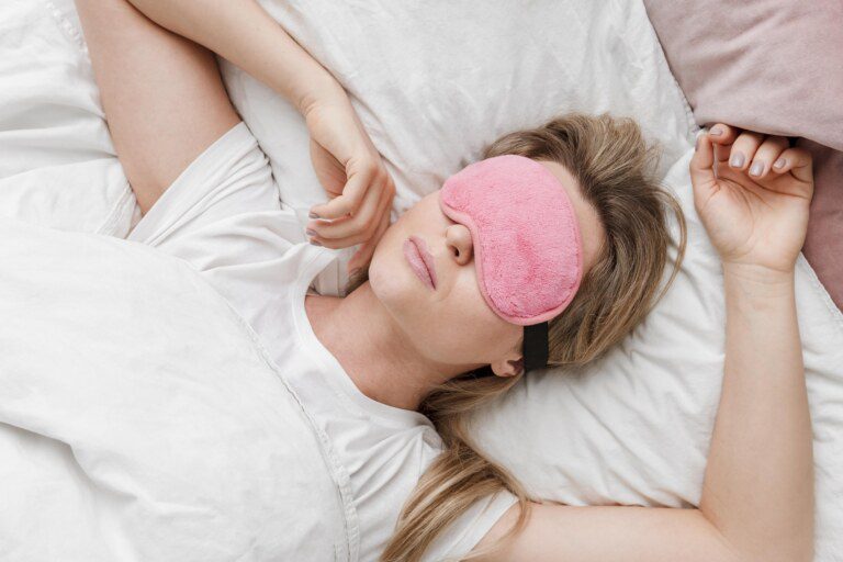 mulher vestindo uma mascara de dormir em seus olhos vista superio